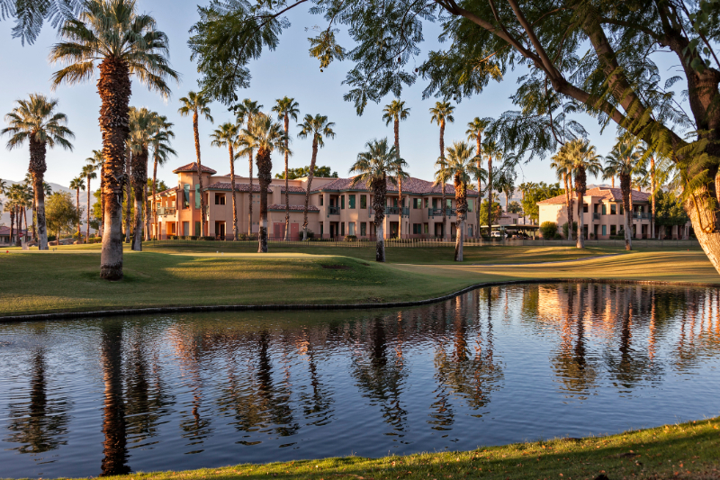 Golf home in Palm Desert surrounded by palm trees and man-made lake